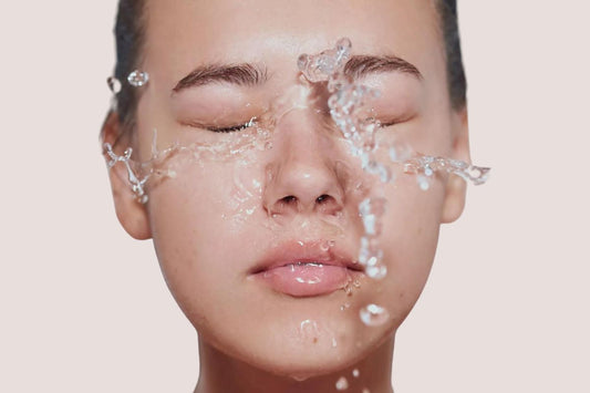 A close up of a face splashed in water