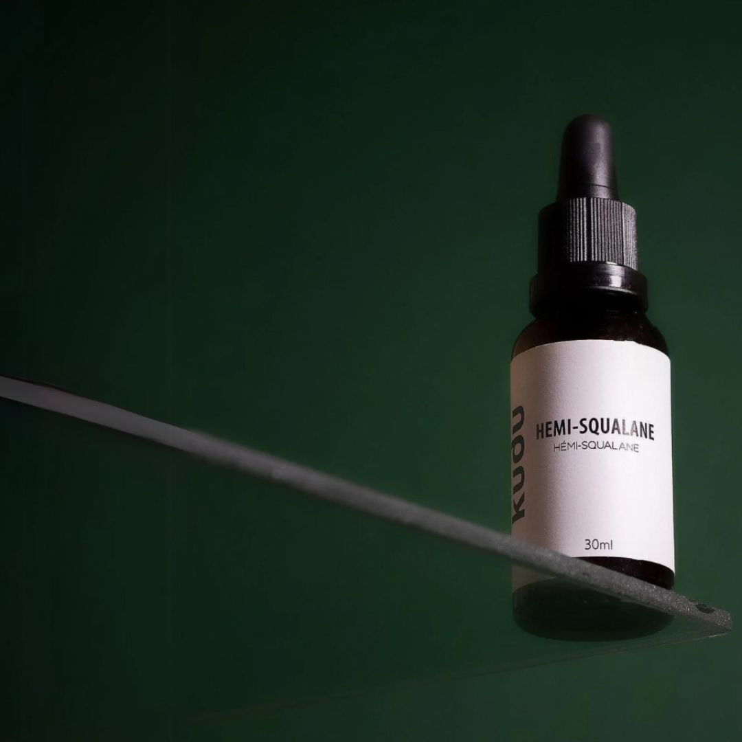 A bottle of Kudu Cosmetica Hemi squalane on a green background