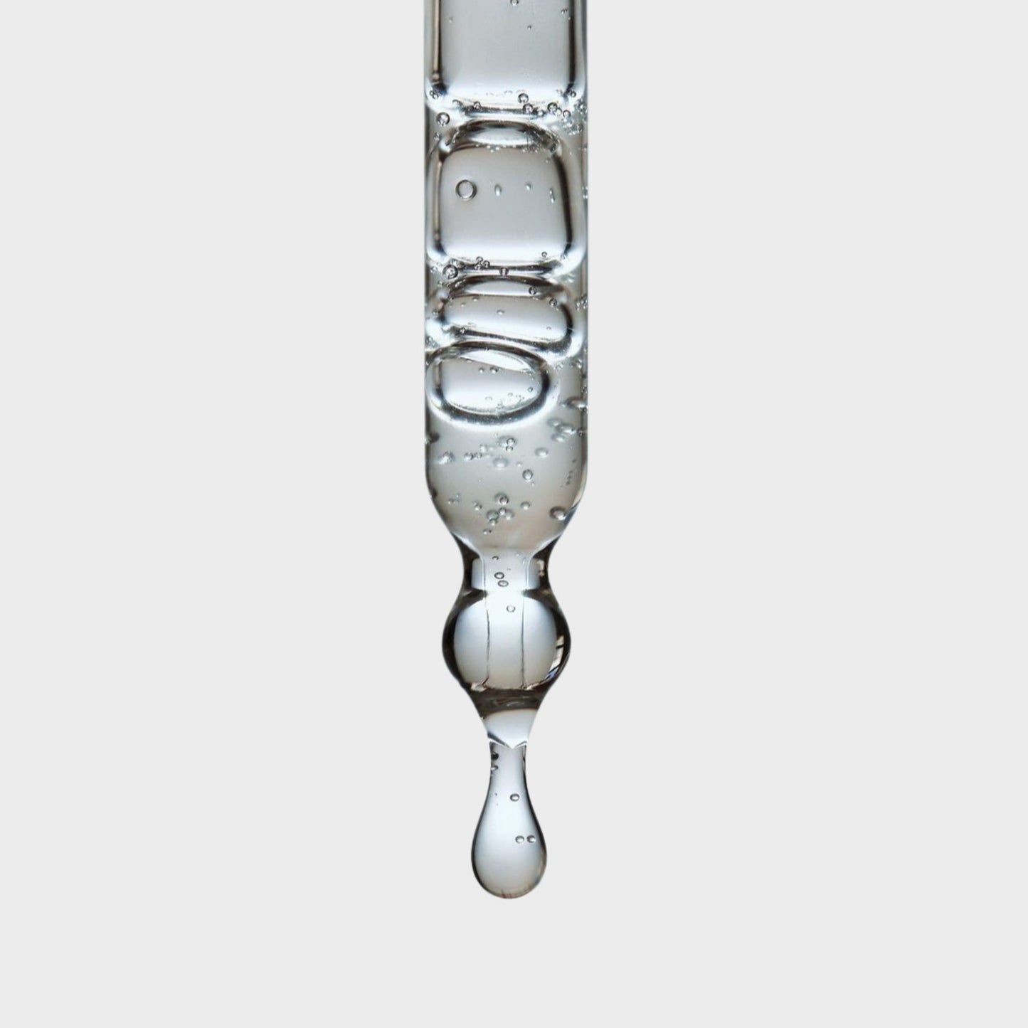 A close-up of a pipette with droplets of  hemi squalane 