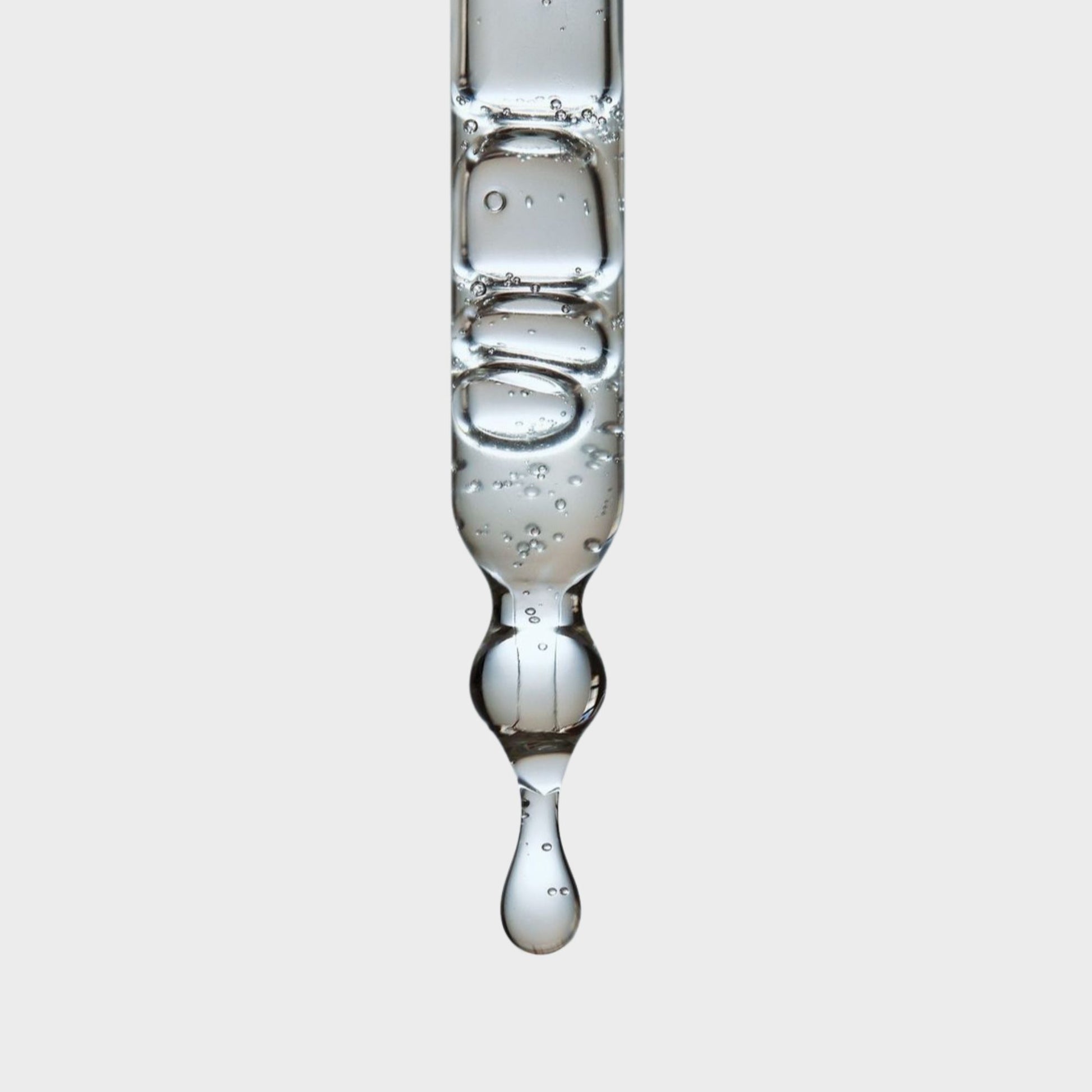 A close-up of a pipette with droplets of  hemi squalane 