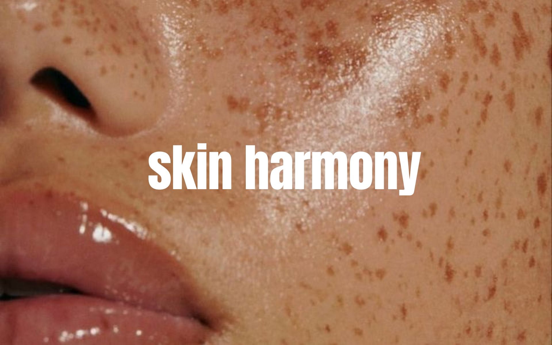 Close-up of a person's freckled face with the words "skin harmony" overlaid on the image.